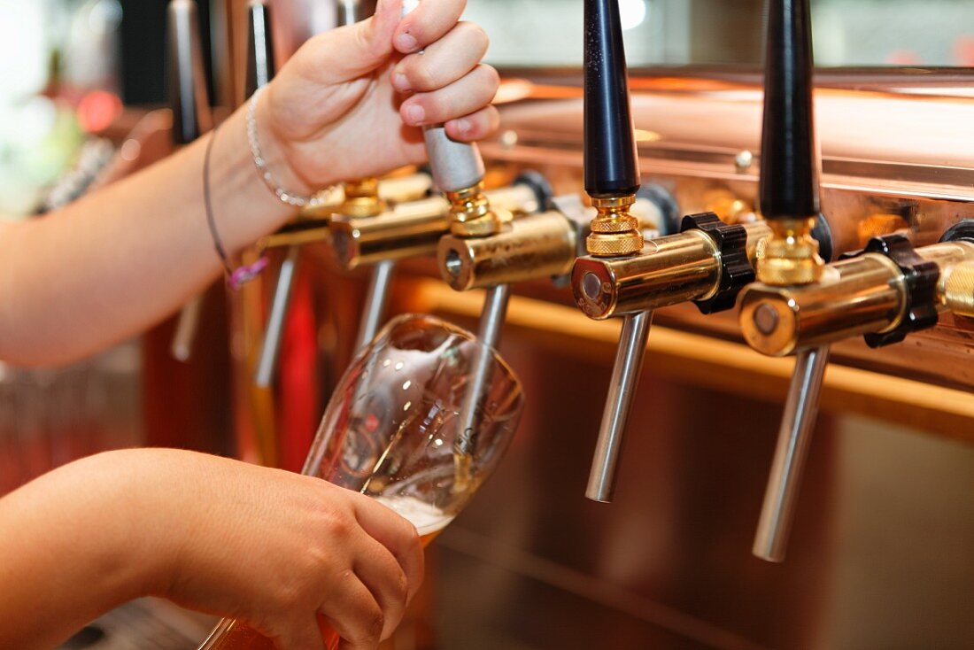 A barmaid drawing a glass of beer