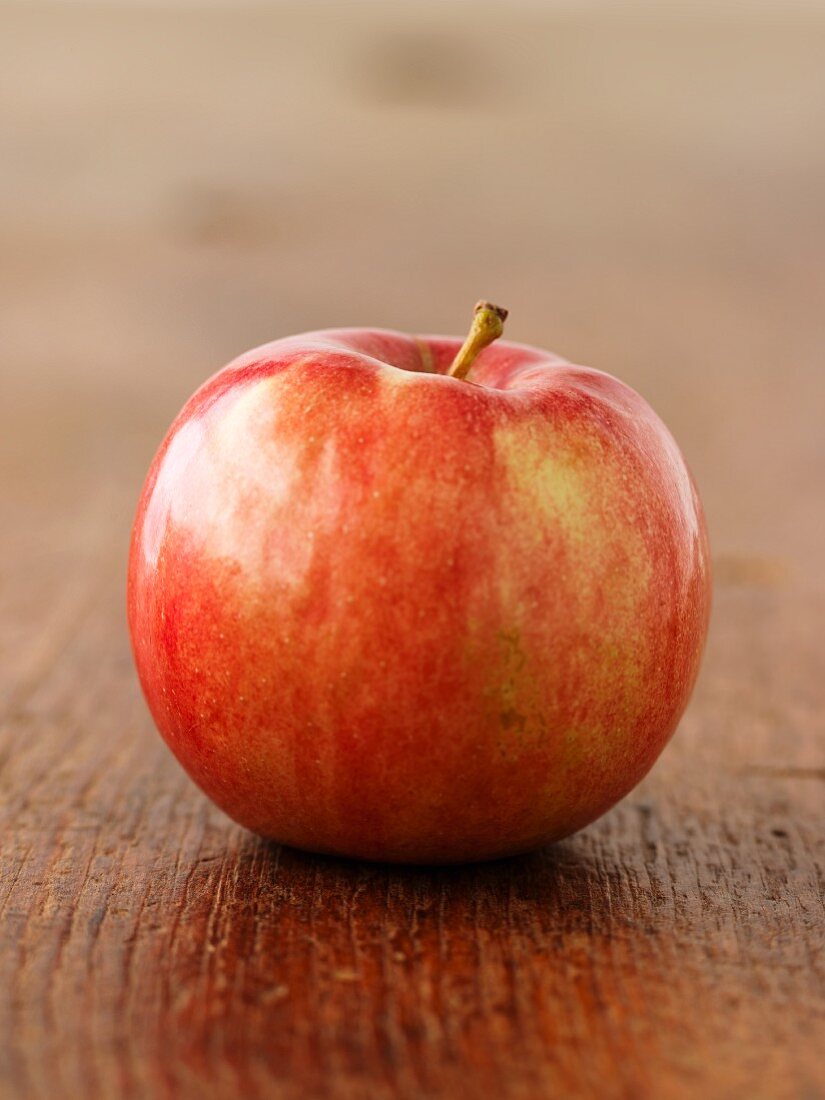 Ein roter Apfel auf Holzuntergrund