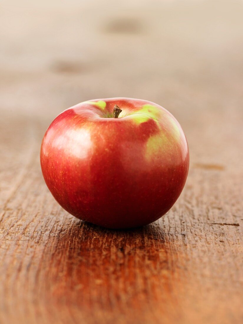 A red apple on a wooden surface