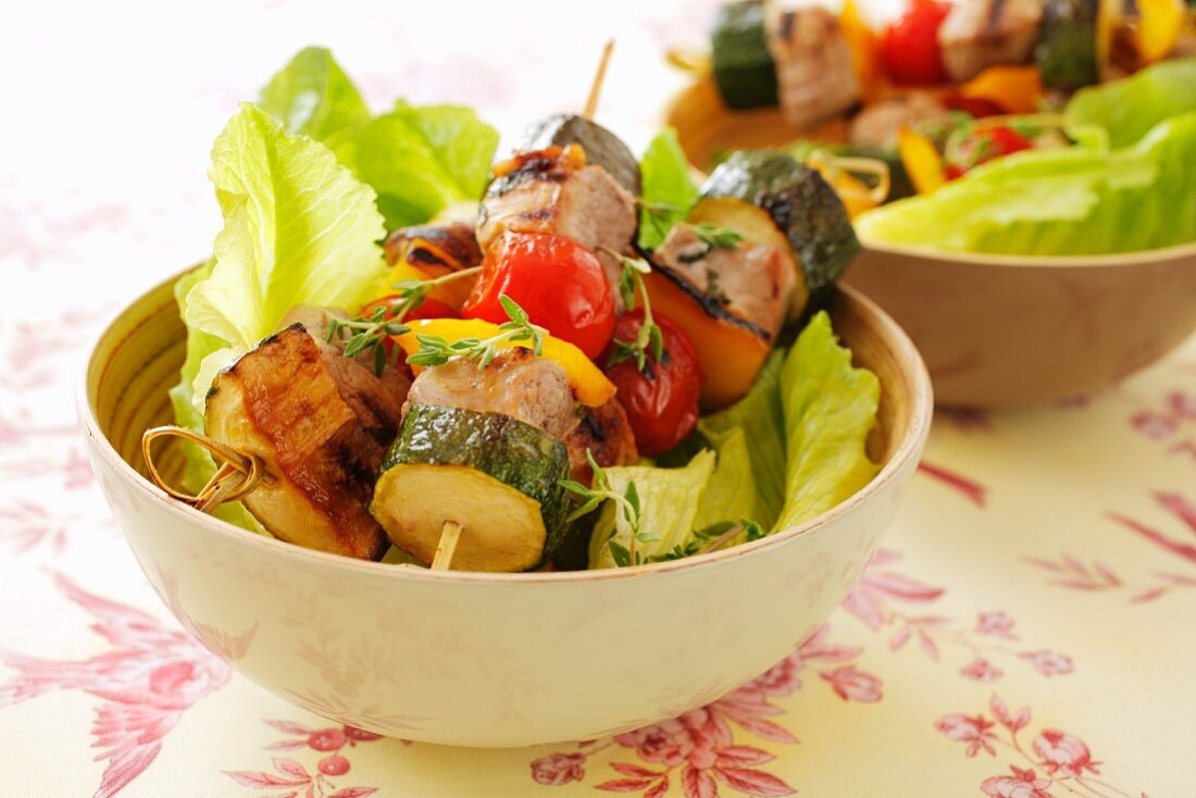 Pork and vegetable kebabs on lettuce