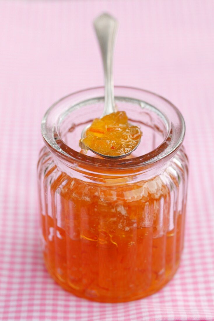 Orangenmarmelade im Glas und auf Löffel