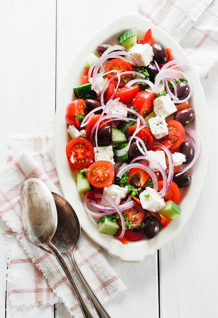 A Greek salad with feta cheese, cucumbers, peppers, tomatoes and olives