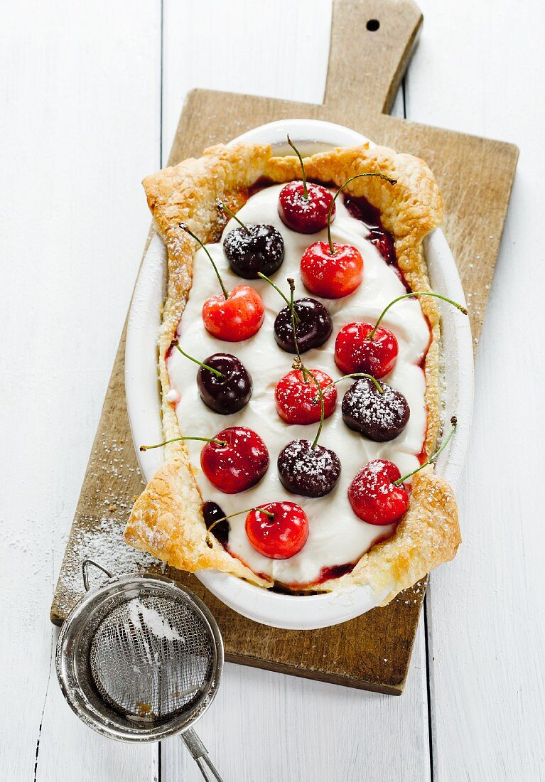A cake topped with cherries, jam and mascarpone