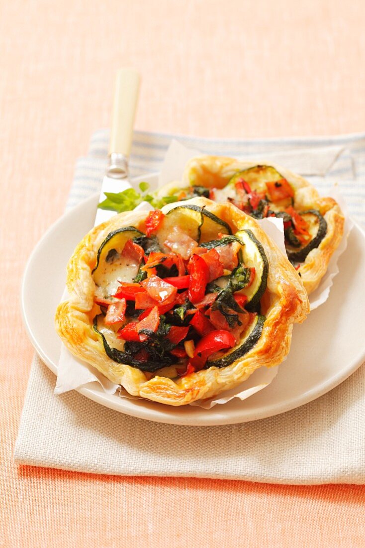 Puff pastry tartlets topped with courgettes, spinach, pepper and mozzarella