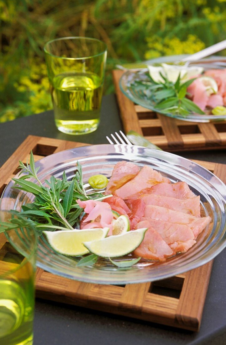 A plate of ham with lime wedges