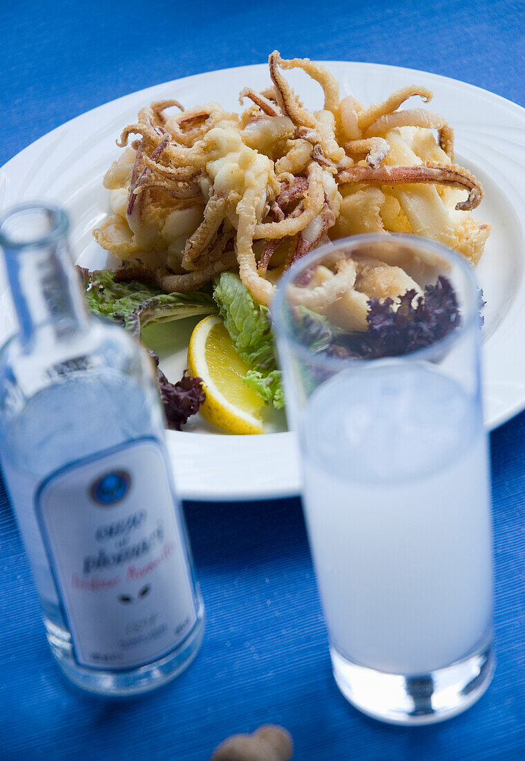 Gebratene Calamari mit Salatblätern und Zitronenspalte, Ouzo