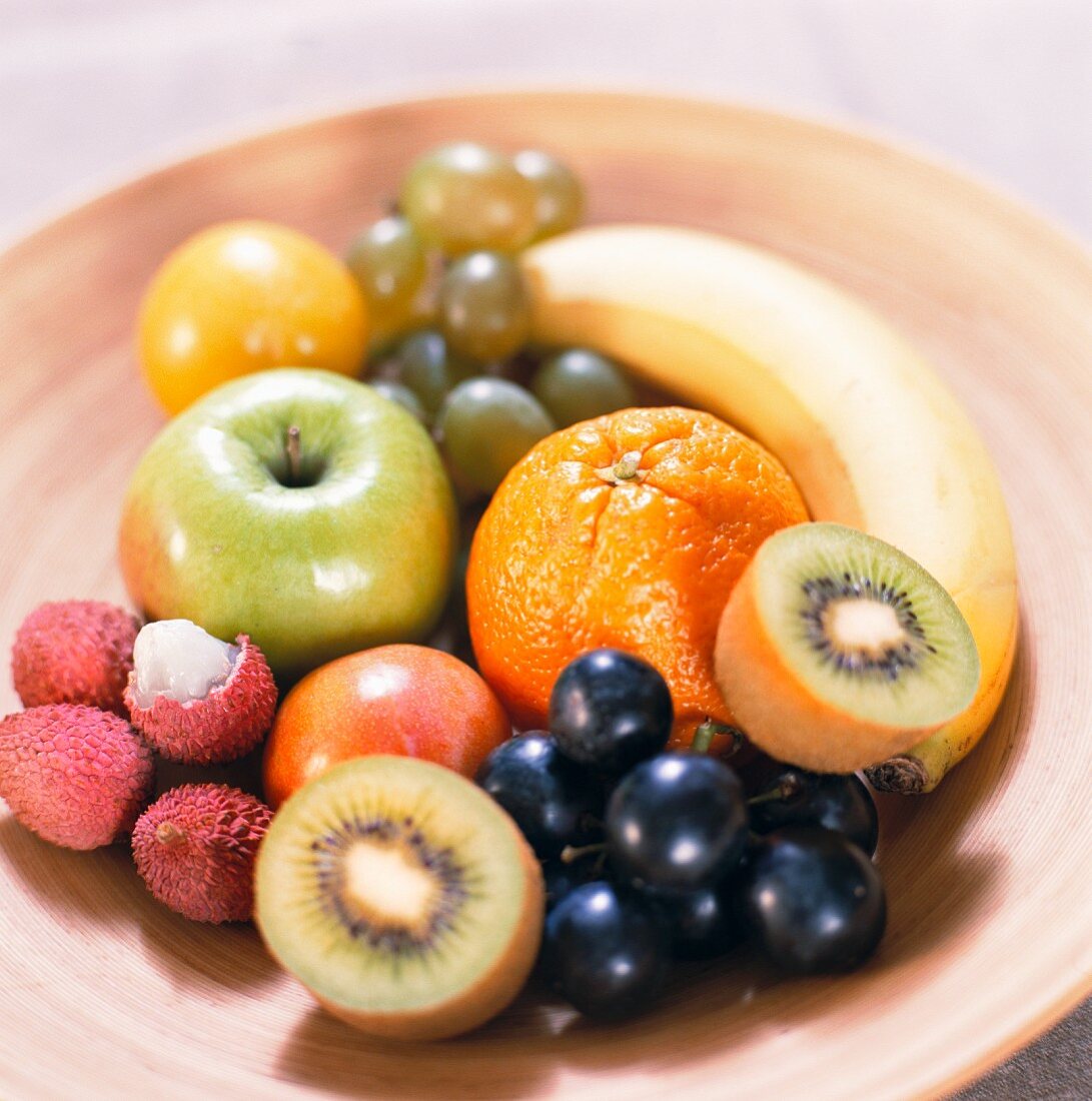 Obstschale mit Trauben, Apfel und exotischen Früchten