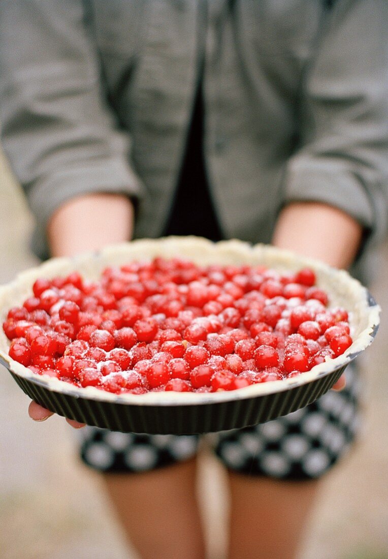 A woman holding a cherry pie