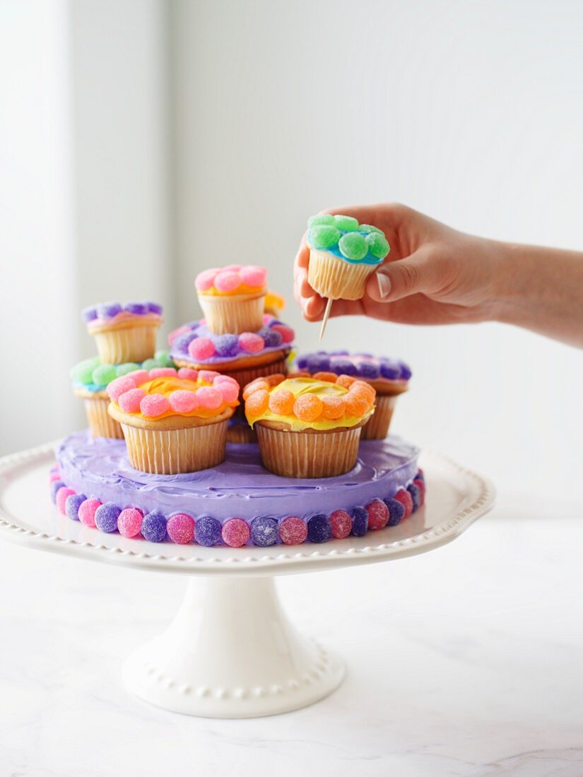 Decorating cake with cupcakes