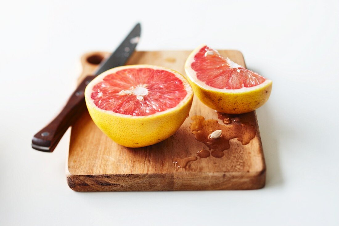 Cut pink grapefruit on chopping board