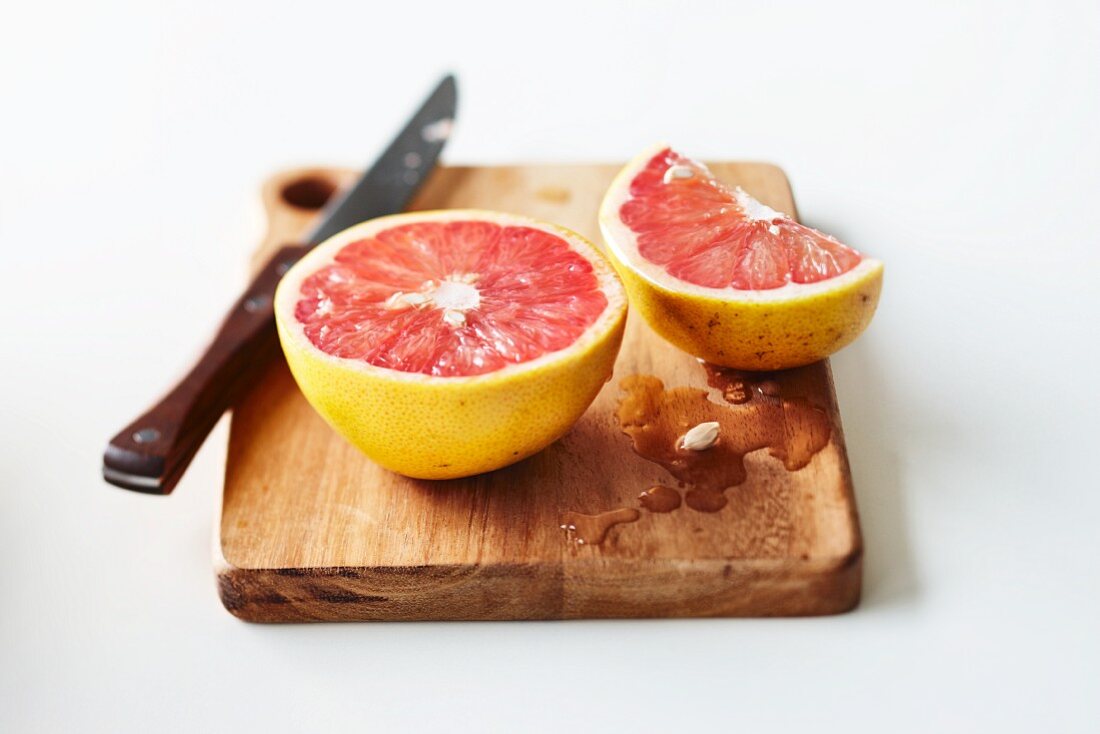 Rosa Grapefruit, aufgeschnitten, auf Schneidebrett