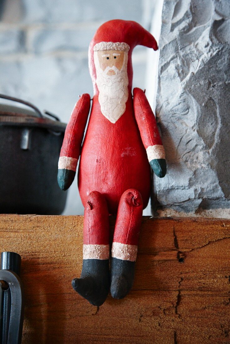 Wooden Father Christmas sitting on mantelpiece