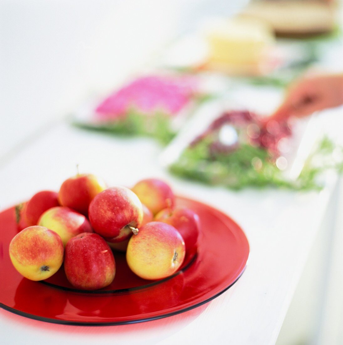 Fresh apples on a red plate