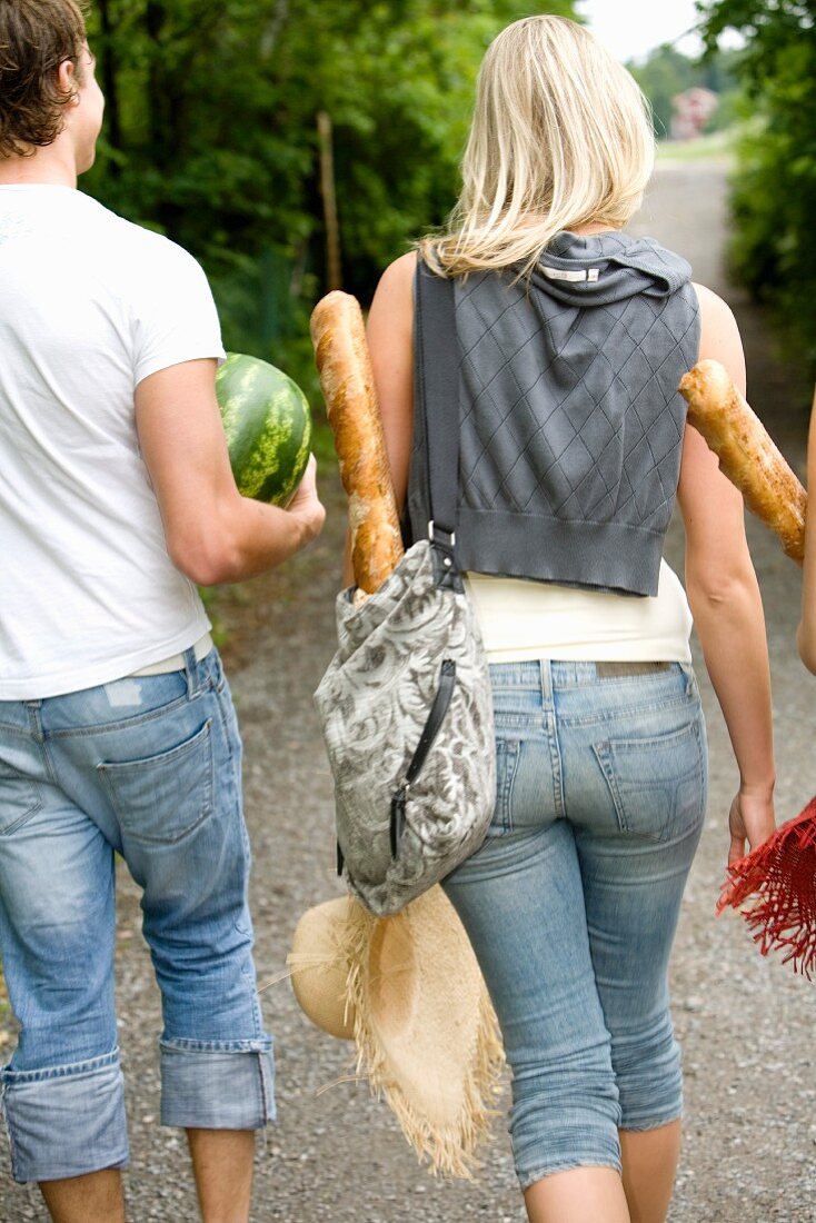 Mann und Frau tragen Baguettes und Wassermelone