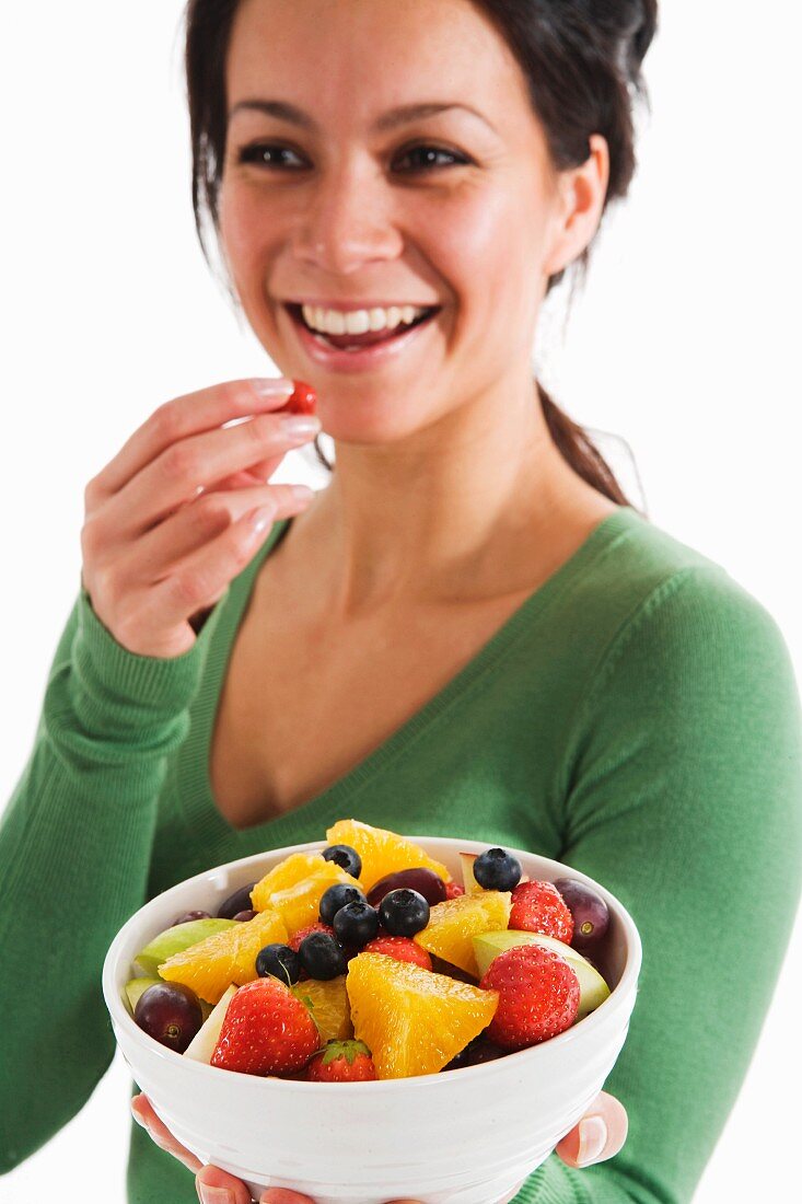 A woman eating fruit salad