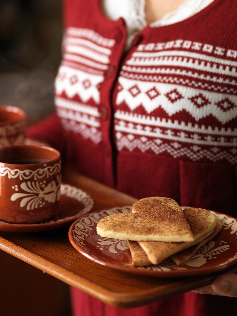 Frau serviert Zimtplätzchen und Kaffee