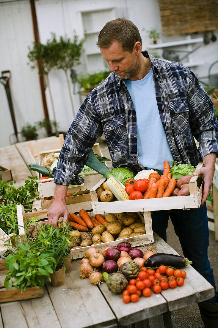 A man holding a crate of fresh vegetables