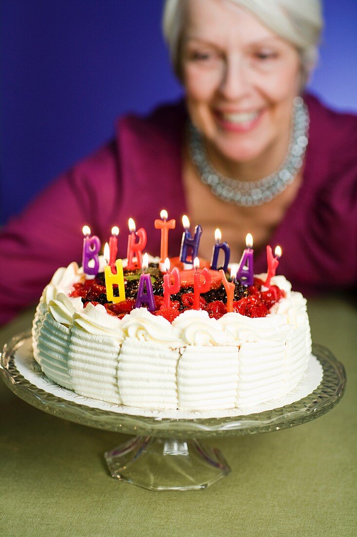 A woman looking at a birthday cake