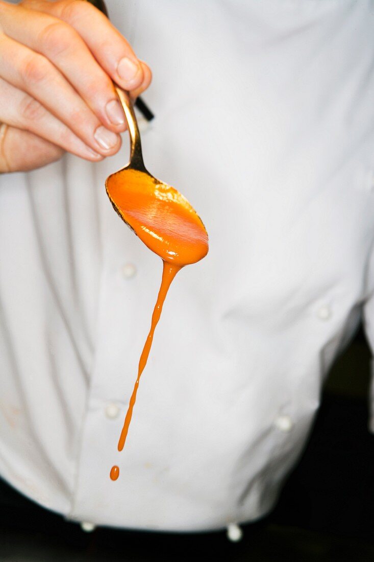 A chef with spoon of sauce