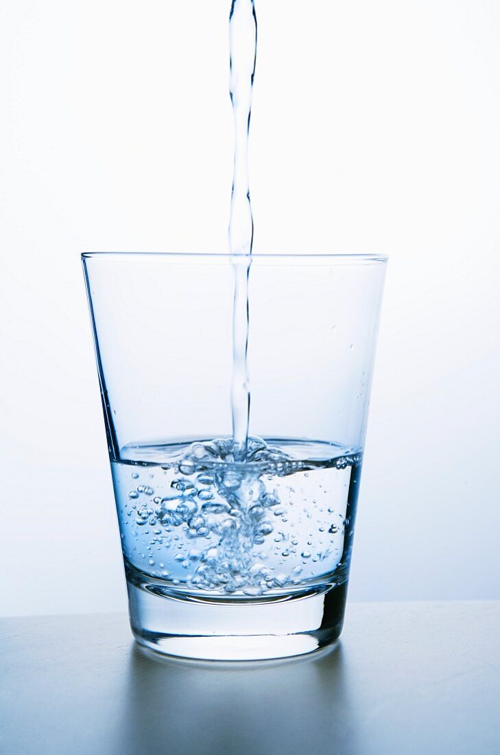 Wasser in Glas einschenken