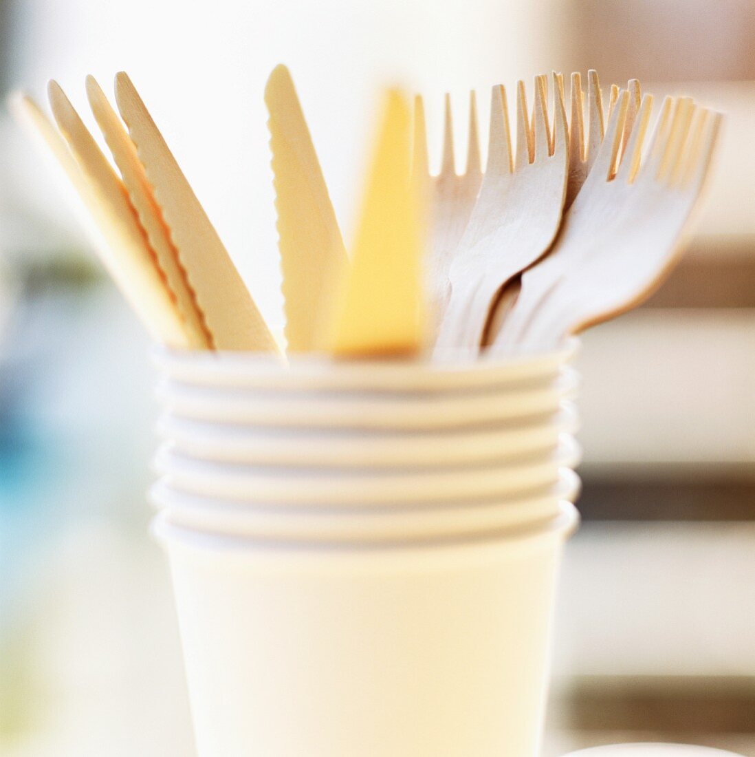 Wooden cutlery in a stack of paper cups