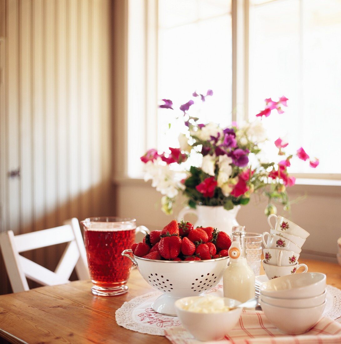 Strawberries, cream and fruit juice on a table