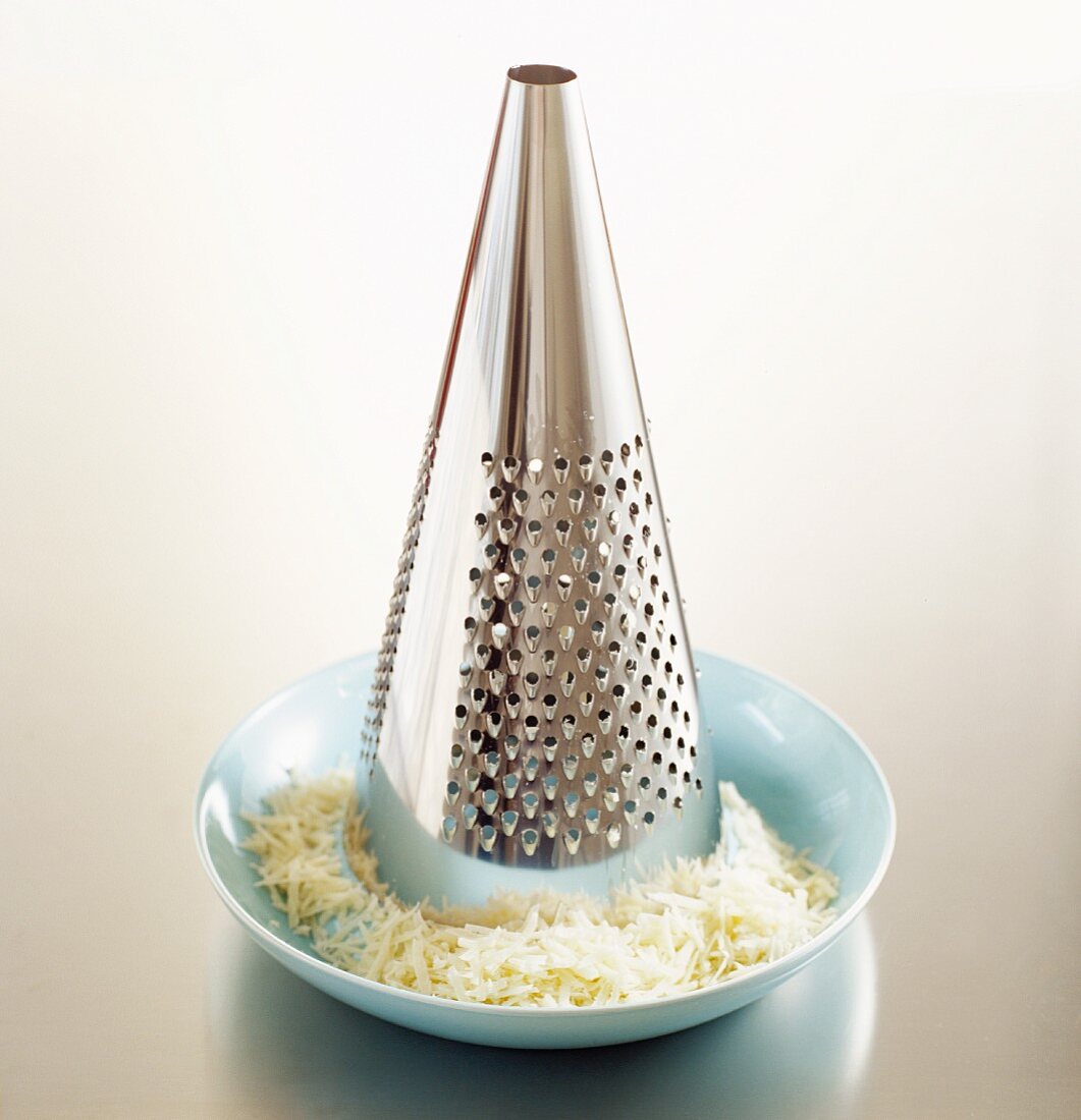 A cheese grater and grated cheese