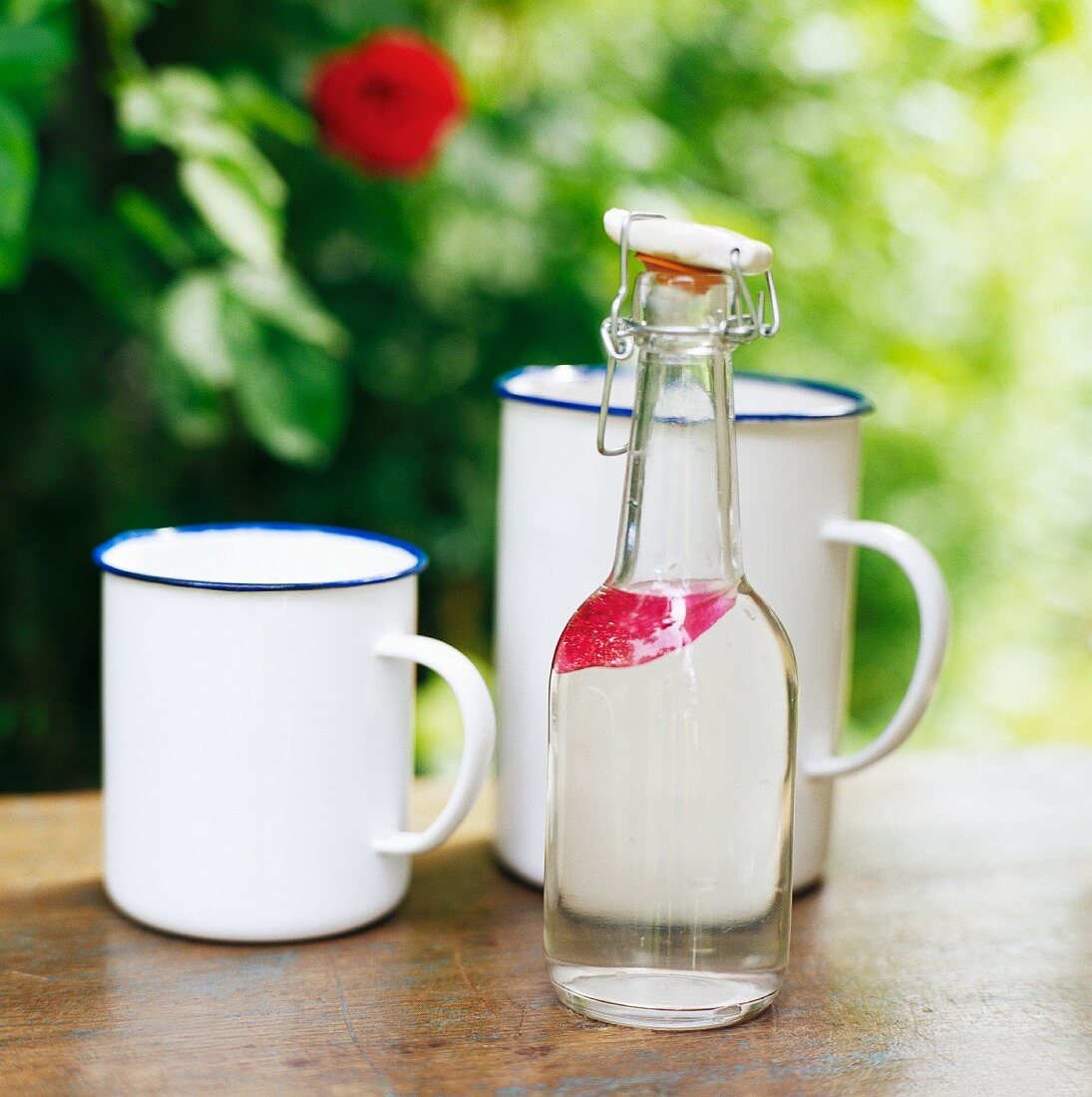 A bottle of water and enamel mugs