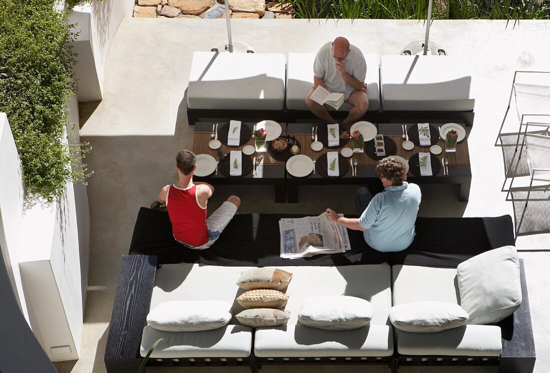 Family at set table on sunny terrace