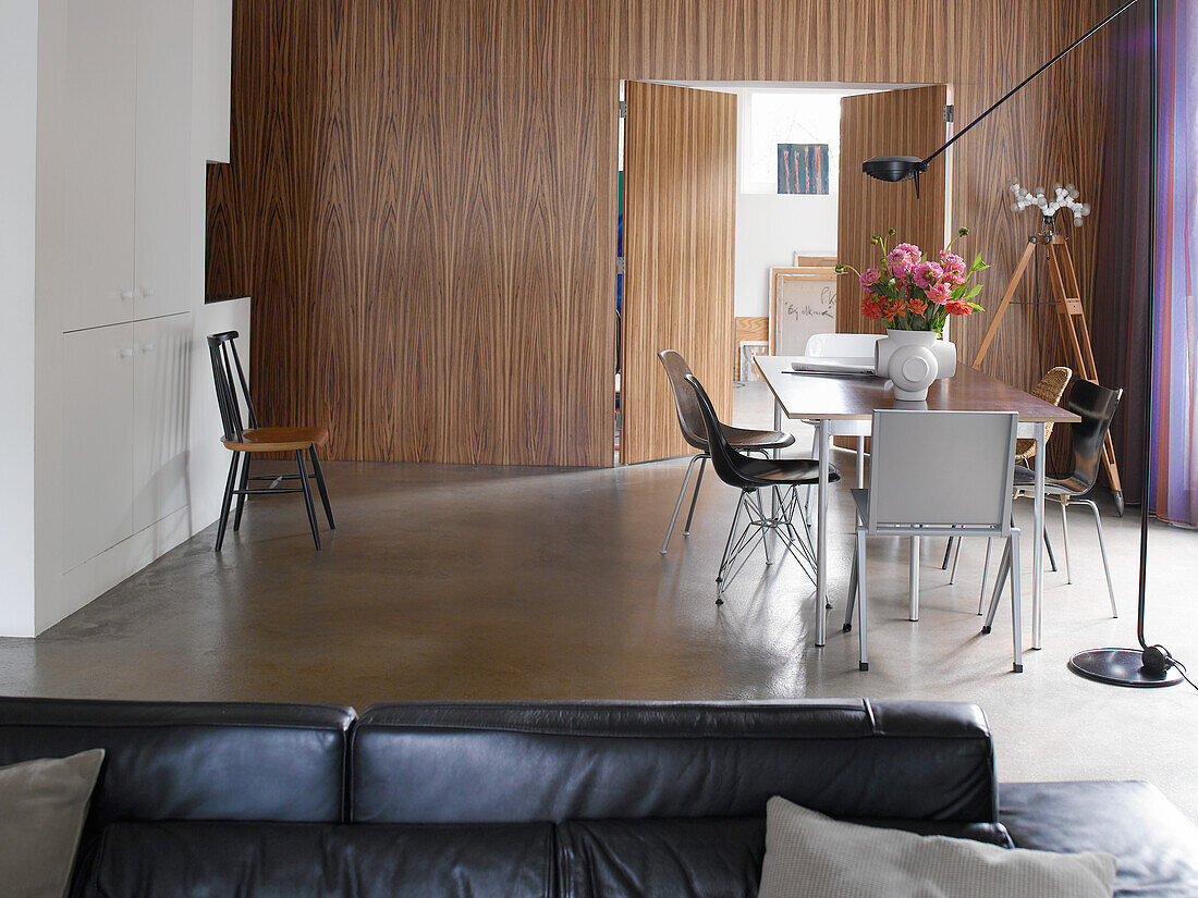 Dining area with wooden wall and modern design, accent with bouquet of flowers