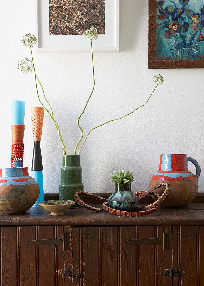 Wooden dresser with vases and jugs, pictures on the wall