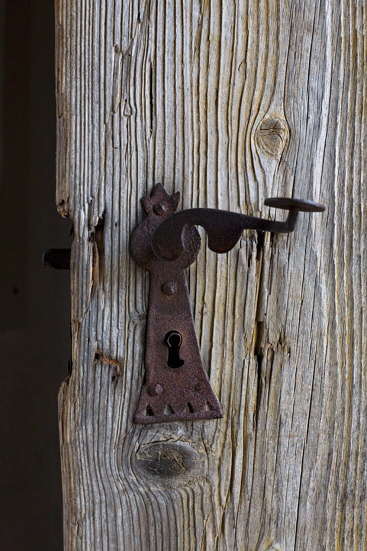 Old, rusty lock and handle on wooden door