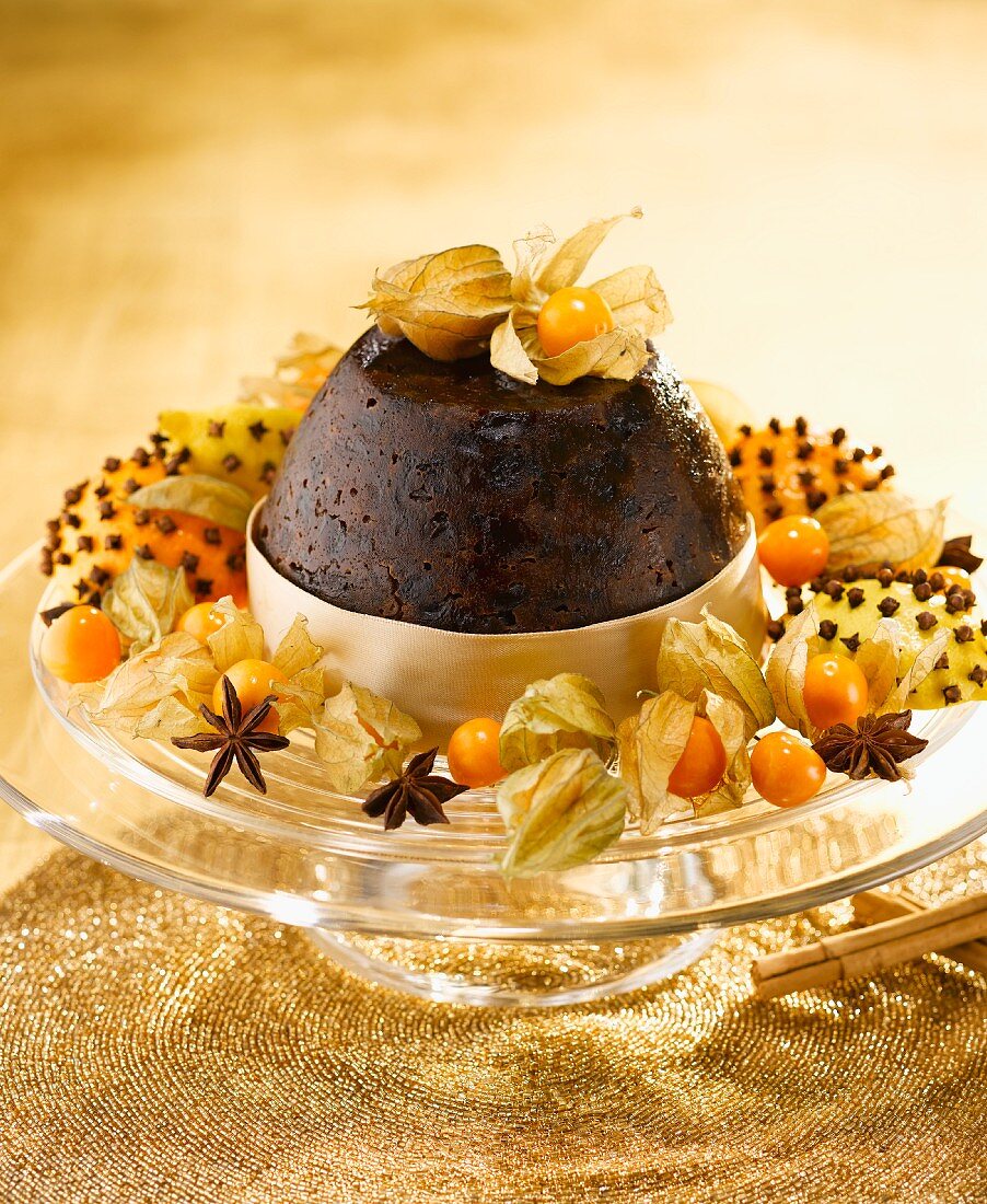 Christmas pudding with cape gooseberries on gold cloth