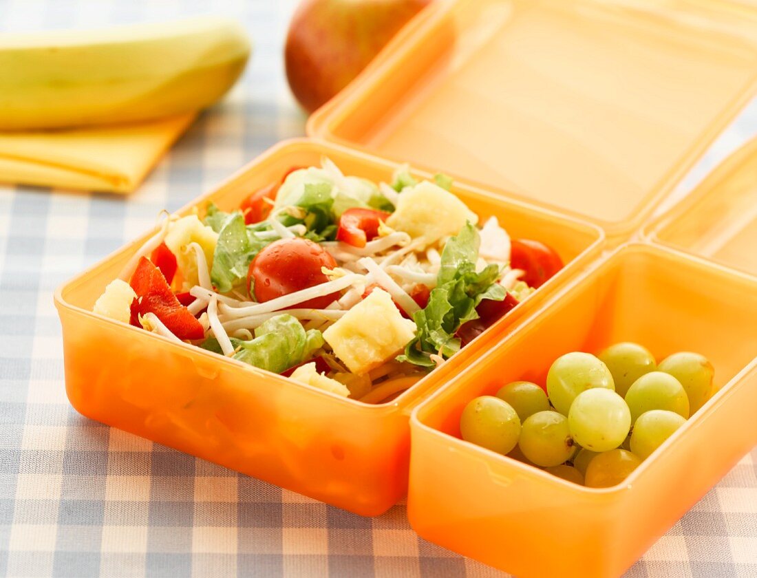 Lunch box with salad and grapes