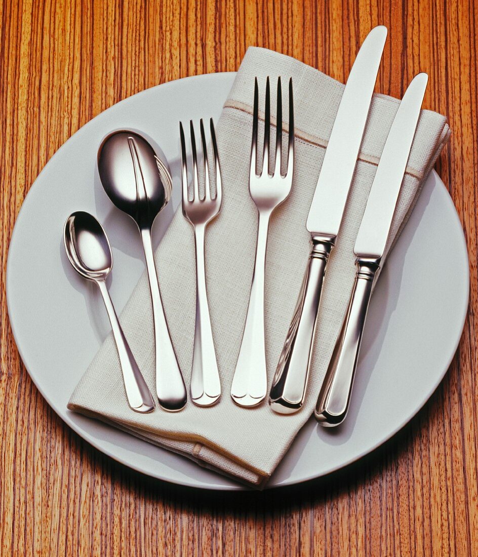 Cutlery and linen napkin on plate