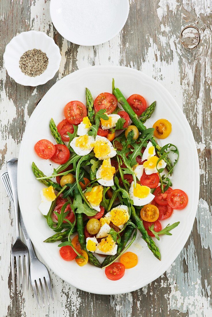 Sommersalat mit gedämpftem Spargel, Rucola, Kirschtomaten, Oliven und Ei