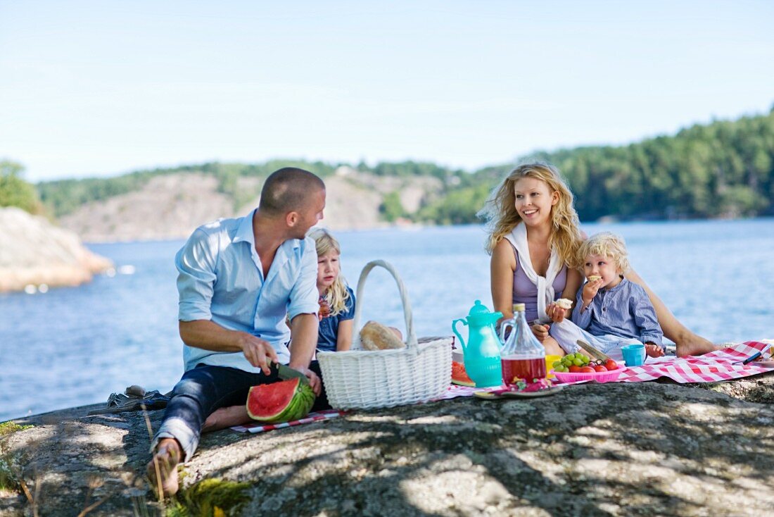 A young family having a picnic by a lake