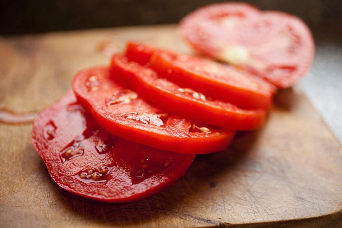 Tomato Sliced on a Wooden Cutting Board