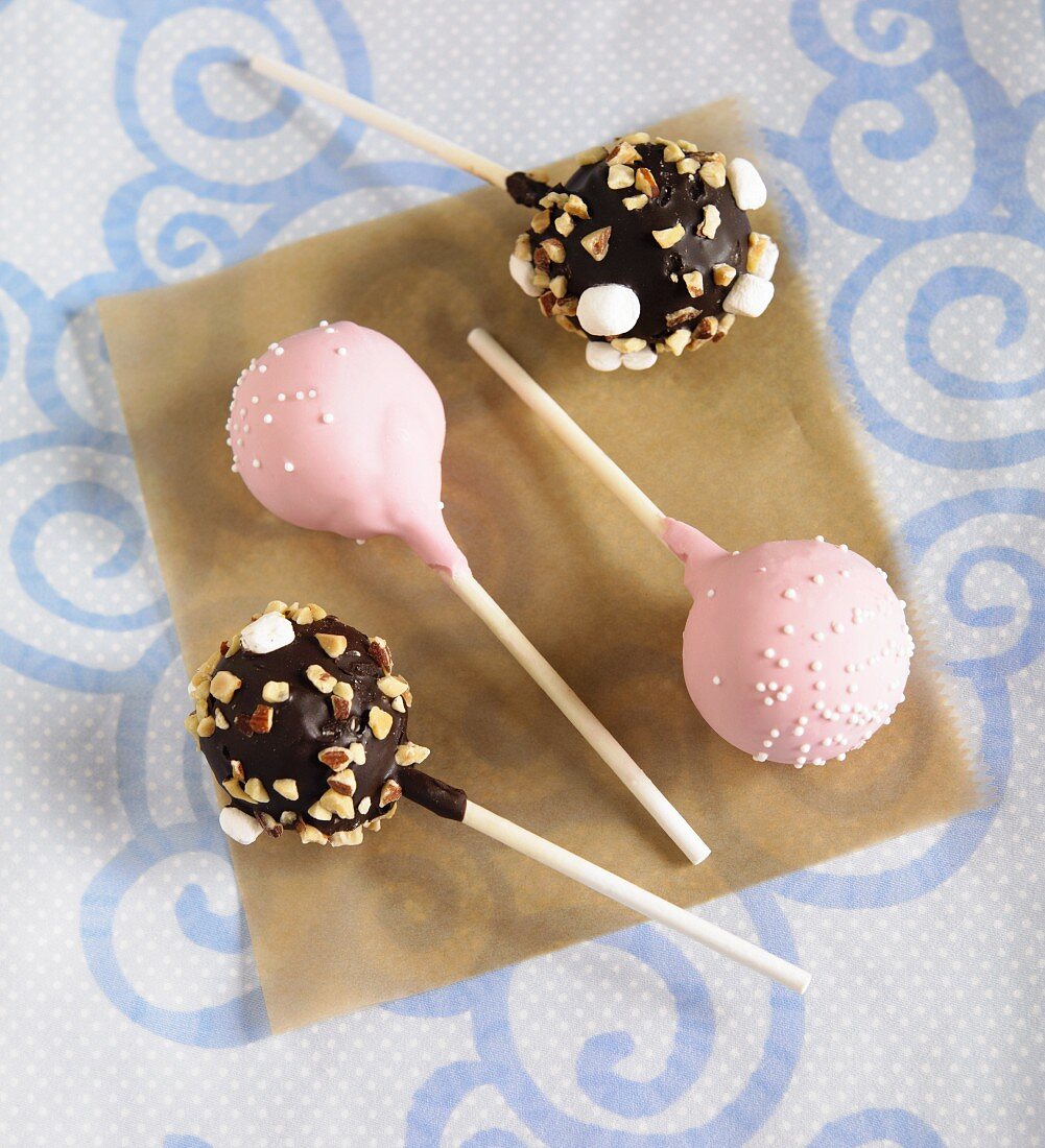 Verschiedene Cake Pops (rosa Glasur, Schokolade mit Nüssen und Marshmallow)