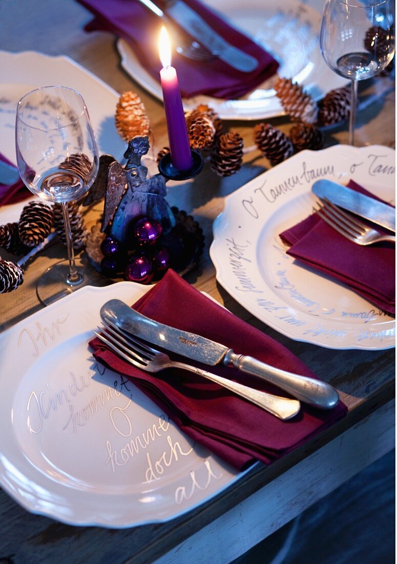 weiße Porzellanteller mit Liedertexten verziert auf einem weihnachtlich gedecktem Tisch