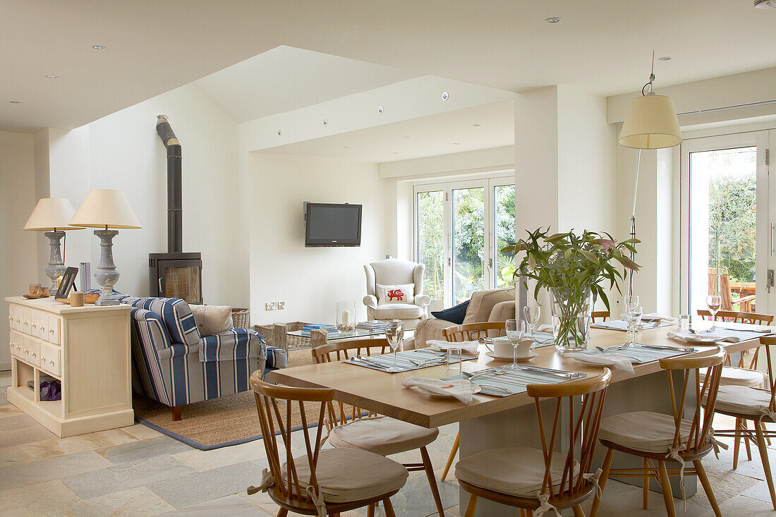 Open-plan living area with dining table, sofas and fireplace