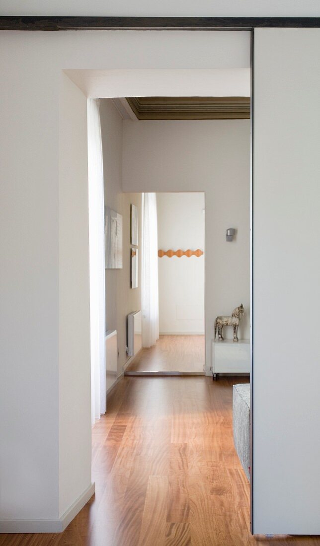 View of room beyond through narrow doorway with sliding partition