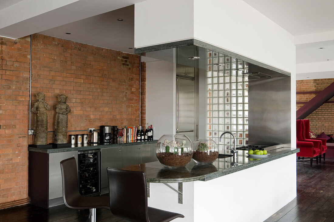 Modern kitchen with counter, glass brick wall and loft-style brick wall