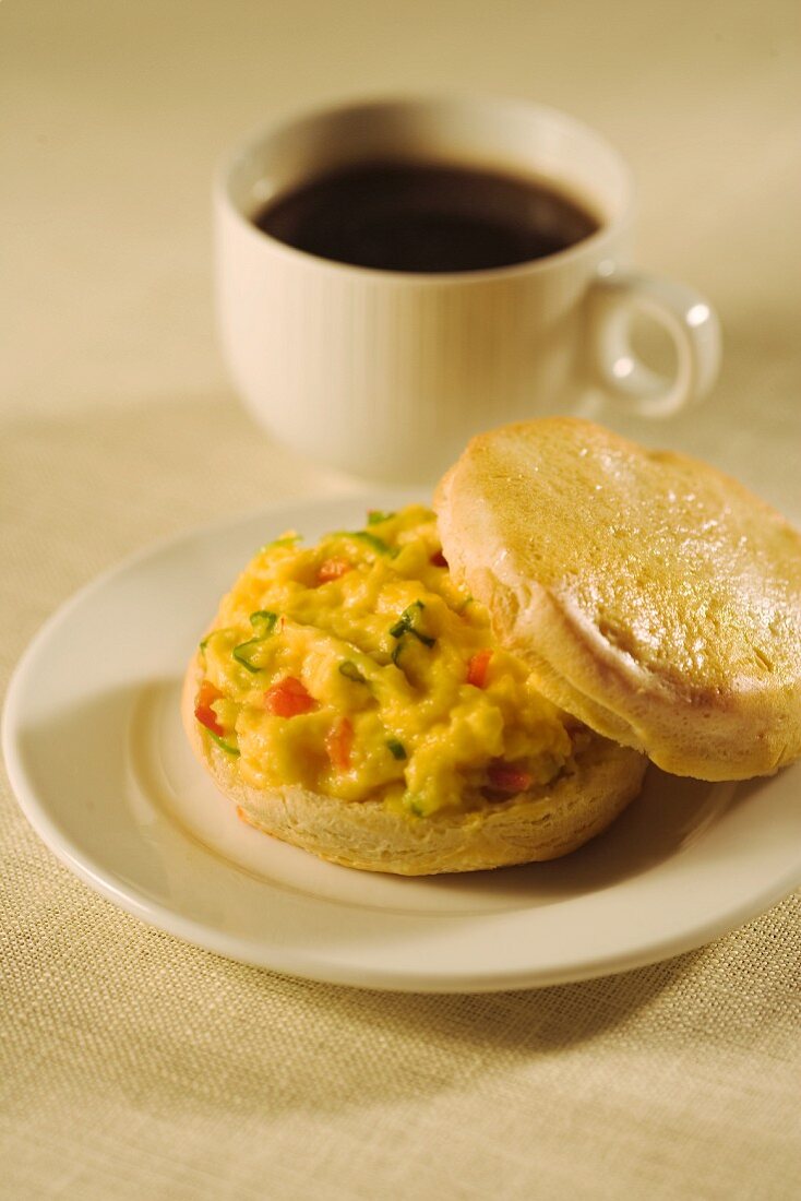 Scrambled Egg Breakfast Sandwich on a Biscuit with a Cup of Coffee