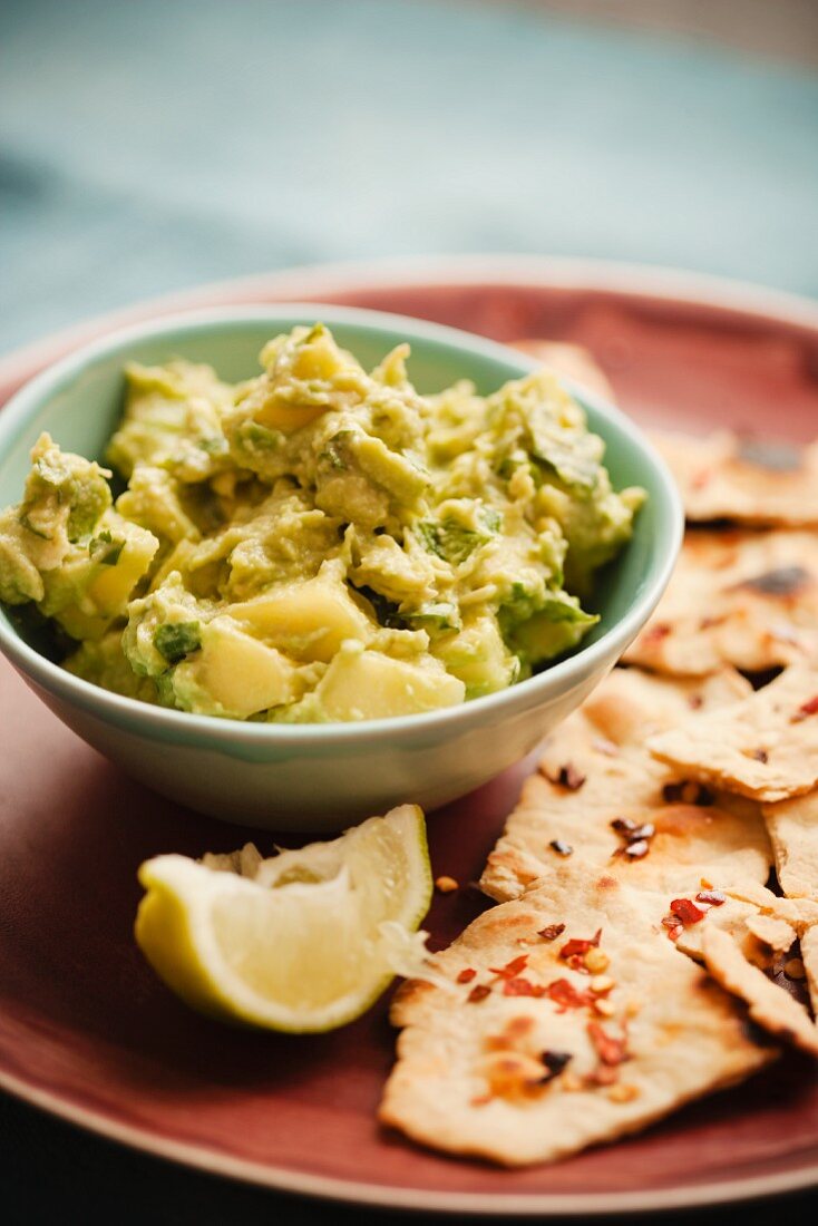 Guacamole mit Tortillas und Zitrone