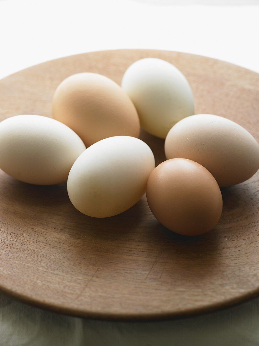 Frische weiße und braune Eier auf einem Teller
