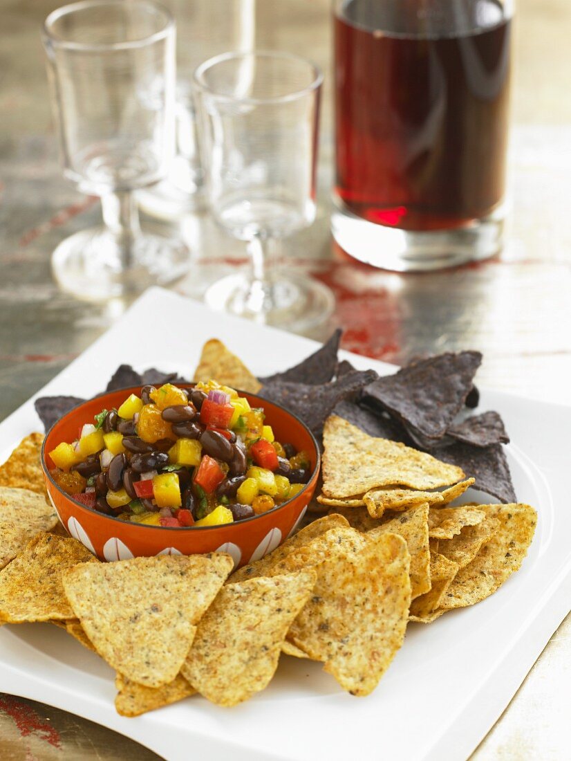 Bowl of Black Bean Salsa with Yellow and Blue Corn Chips