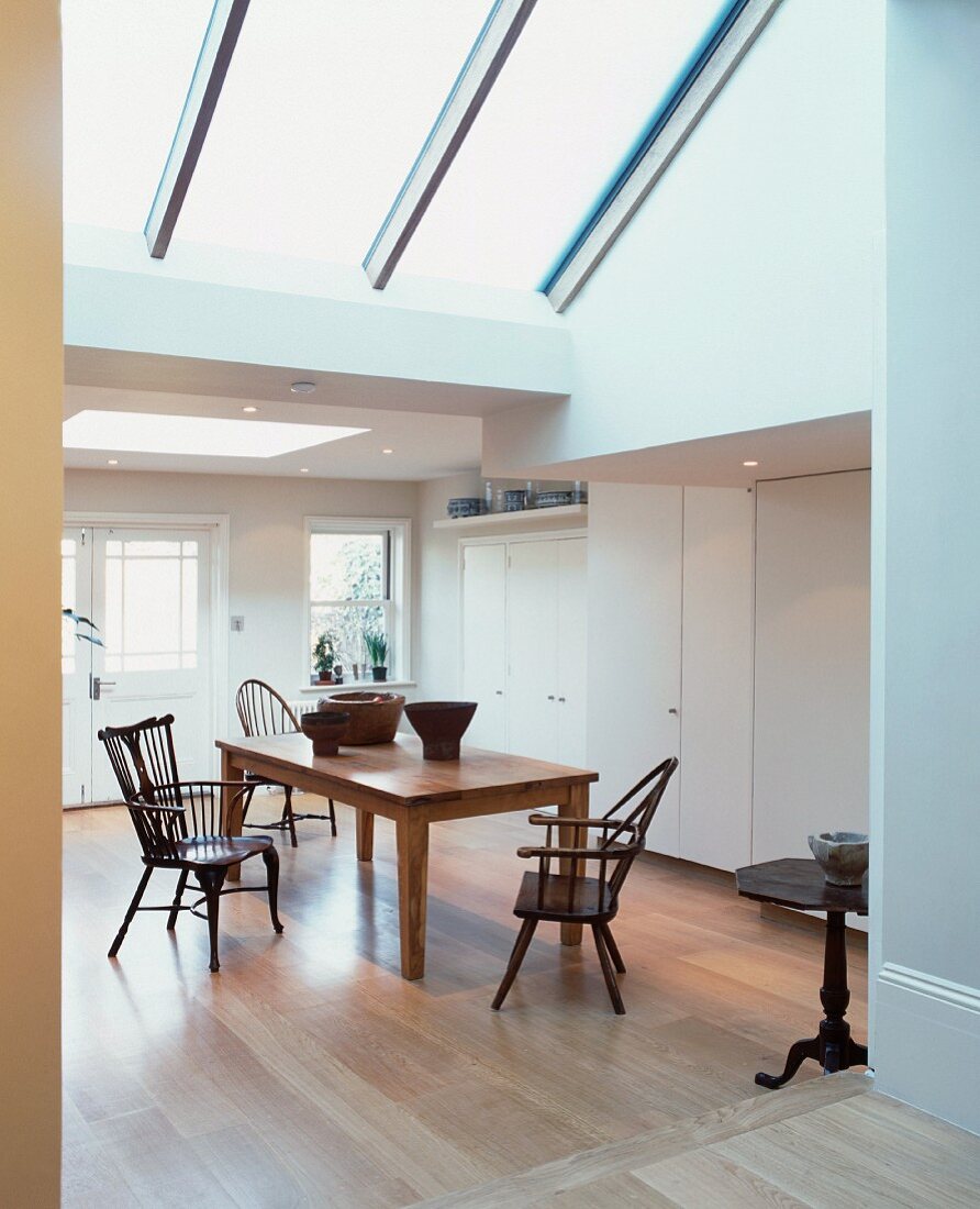 Dining area in open-plan living space in converted loft with large skylights