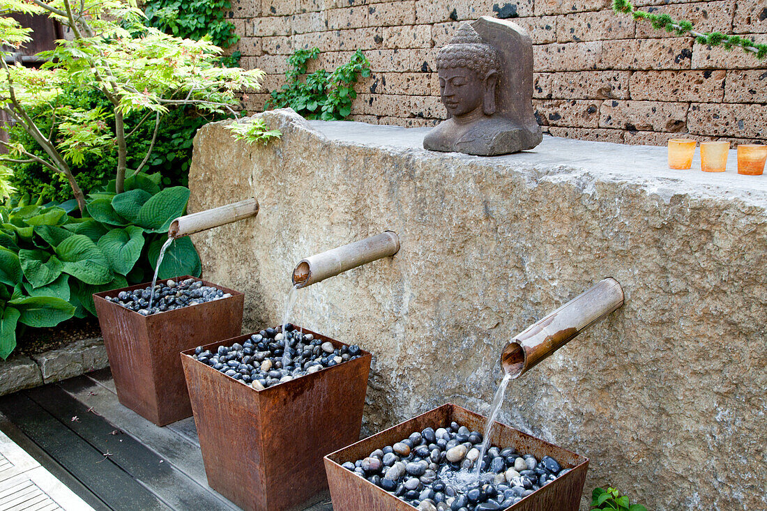 Watercourse made of bamboo tubes and stone sculpture in the Zen garden