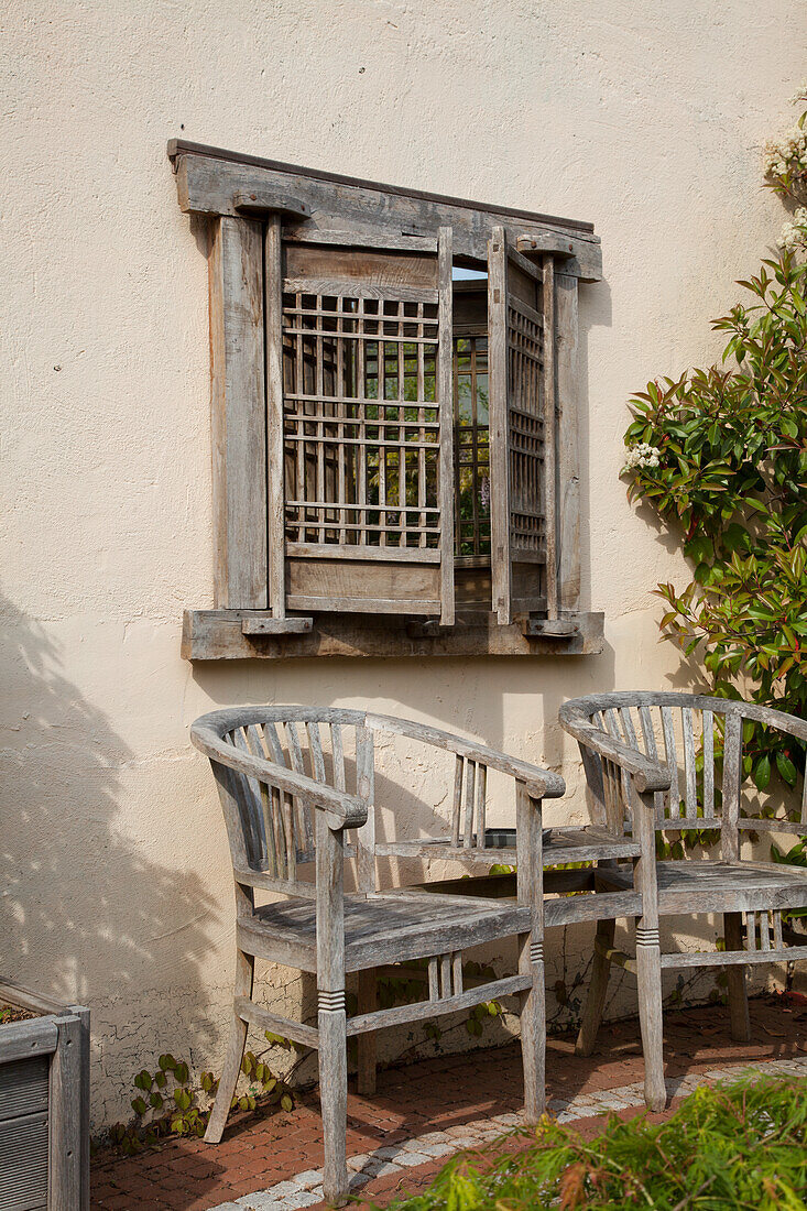 Holzstühle und Fensterläden im Vintage-Stil an Außenwand